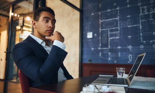An entrepreneur in property management thinking at his desk.