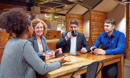 Business people sitting at a table having coffee together.