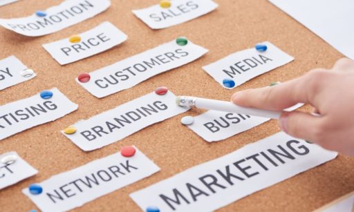 A bulletin board indicating different marketing strategies and elements. A hand points to the one that says “branding.”