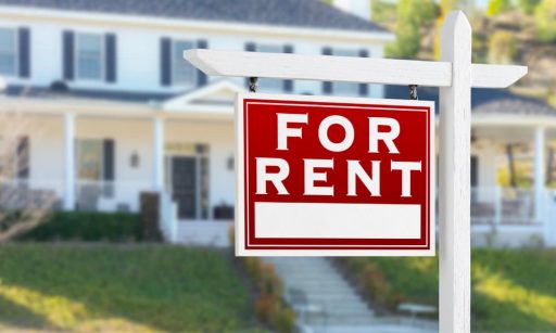 a for-rent sign in front of a rental house