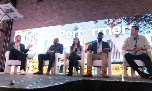 Conference attendees stand chatting with each other between formal sessions.