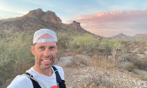 A selfie of Mark Brower on a hike in a desert-like landscape.